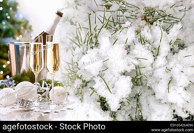 Beautiful Christmas background: Christmas tree in the snow, glasses of champagne, beautiful decorations for the Christmas tree