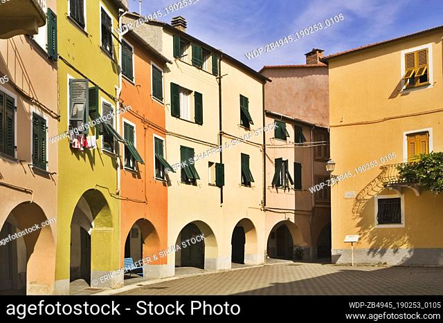 Pastel coloured houses with archways on Piazza Fieschi that form the round old centre of the town