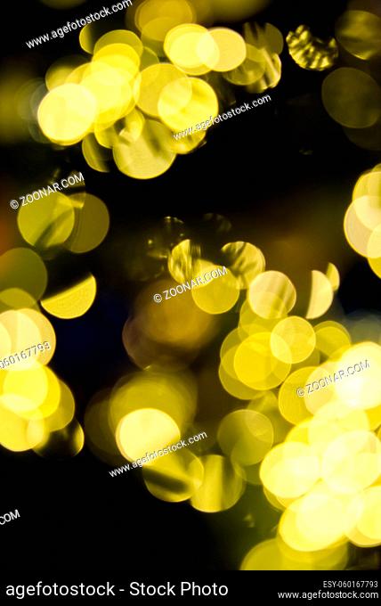 blurred christmas lights abstract background on dark backdrop. Yellow Circular reflections of Christmas lights