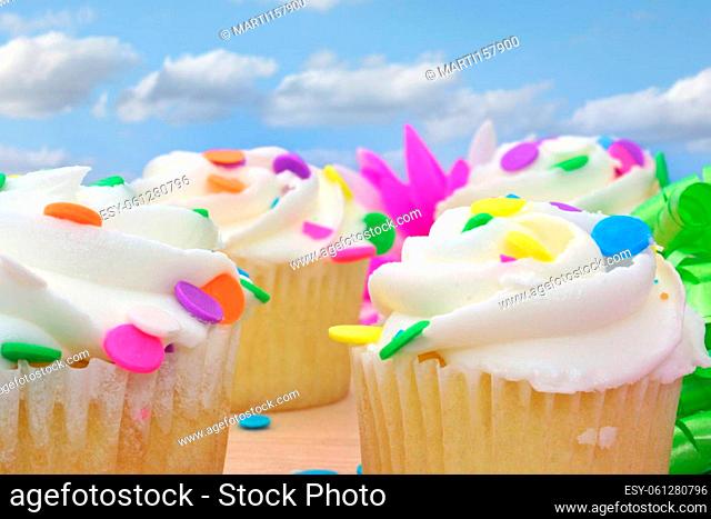 Cupcakes and Flower with Beads and Ribbon on Wooden Table