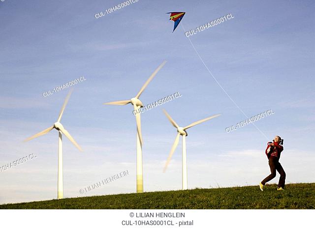 Girl Flying Kite at Wind Turbines