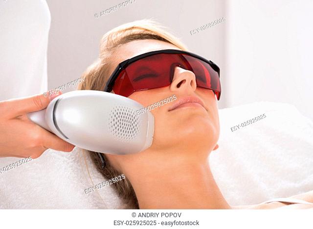 Closeup of young woman undergoing laser treatment at salon