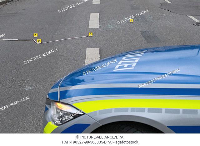 27 March 2019, Bavaria, München: Forensics tags are on a crime scene on the street. A policeman shot an escaping vehicle