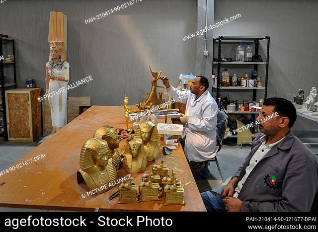 13 April 2021, Egypt, Obour City: Craftsmen work on creating model replicas of ancient Egyptian artifacts, at Konouz factory