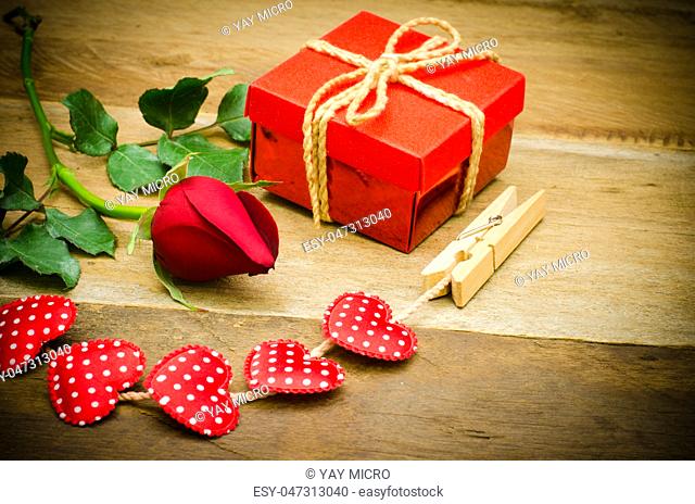roses and gift box on wooden background