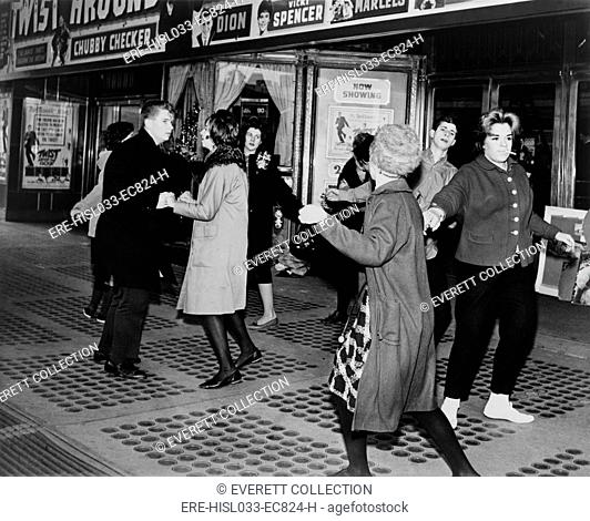 Teens dancing the 'Twist' outside the Brooklyn Fox Theatre before the premiere of the movie 'Twist Around the Clock'. 1961