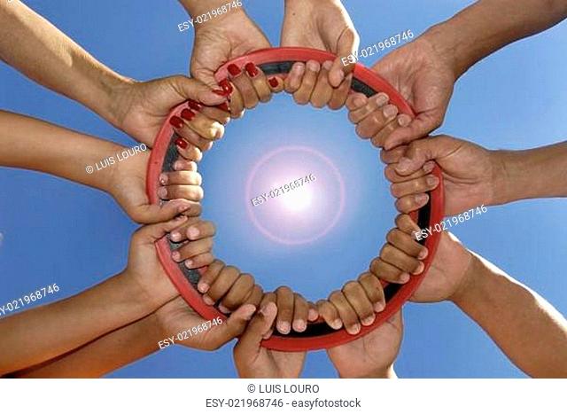 Several hands holding a disc together