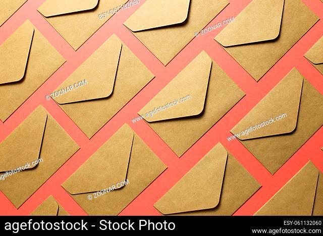 Kraft brown paper envelopes on pink background