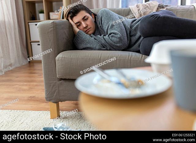 depressed woman lying on sofa at home
