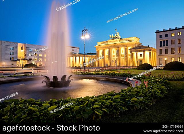 Beleuchtetes Brandenburger Tor mit Springbrunnen und dem Pariser Platz am Abend, Berlin, Deutschland, Europa