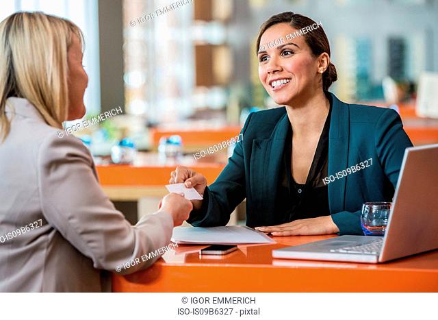 Businesswomen making introductions in cafe
