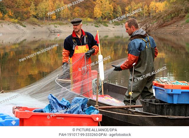 15 October 2019, Saxony-Anhalt, Hasselfelde: Professional fisherman Gernot Quaschny (l) and Sven Ahlendorf fish the small whitefish