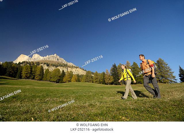 Young couple hiking under blue sky, Rosengarten, Dolomites, South Tyrol, Italy, Europe