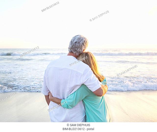 Caucasian couple hugging on beach