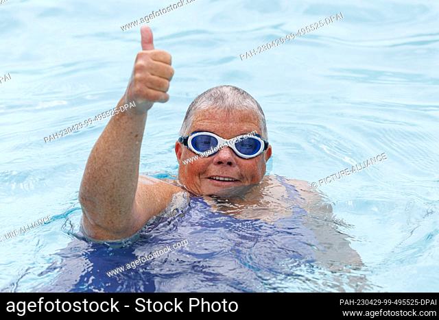 28 April 2023, North Rhine-Westphalia, Paderborn: A swimmer gives the thumbs up at the Rolandsbad outdoor pool at the start of the outdoor pool season in North...