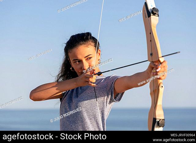 Archeress aiming with bow and arrow