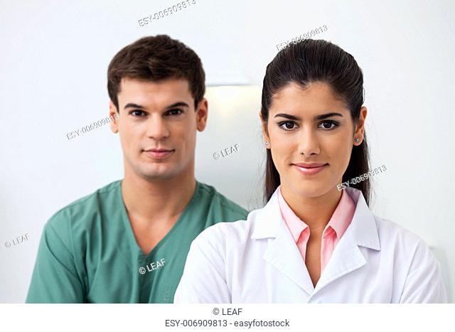Portrait of female dentist standing with her assistant
