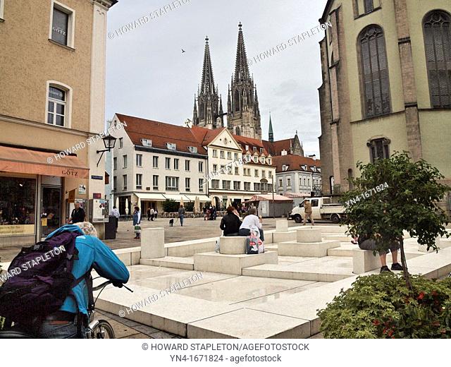 The Regensburg Cathedral towers over the Neupfarrplatz  The white stonework in the foreground is a work of art by Dani Karavan and known as 'The Meeting Place'...