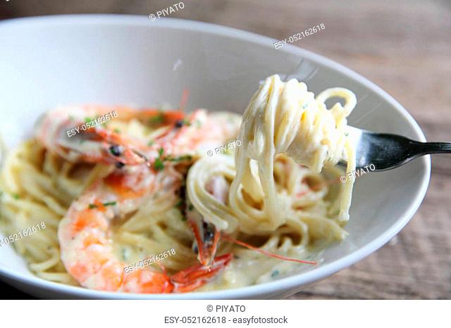 Spaghetti white sauce with shrimp on wood background