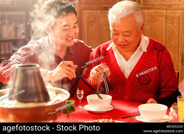 Happy father and son to eat hot pot together