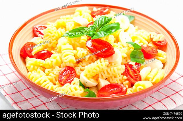 Pasta salad with tomatoes, olives, mozzarella and basil