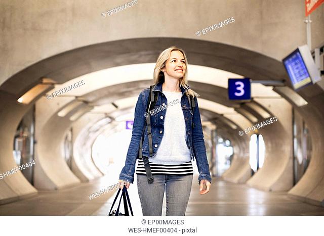 Smiling woman standing in underpass at the station
