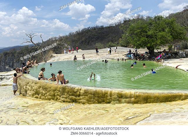 People bathing in the artificial pool filled with water from fresh water springs, whose water is over-saturated with calcium carbonate and other minerals at...