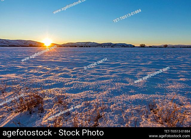 USA, Idaho, Bellevue, Sun setting over snowy field