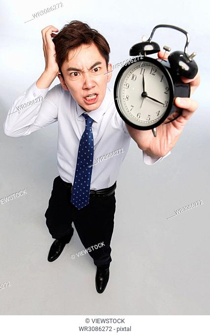 Business young man with an alarm clock