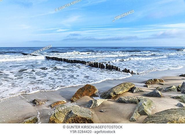 Beach with stones and old groynes on the Baltic Sea. Groynes are intended to break the shaft and to prevent the erosion of the coast