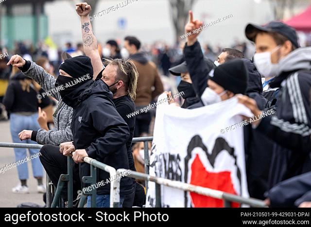 01 May 2021, Thuringia, Erfurt: Counter-demonstrators stand next to the rally of the right-wing extremist group ""Neue Stärke Erfurt"" on Erfurt's Domplatz
