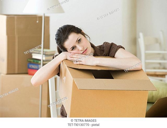 Woman resting on moving box