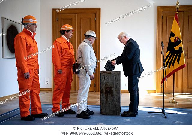 03 April 2019, Berlin: Miners from the RAG mines hand over the last piece of hard coal mined in Germany to Federal President Frank-Walter Steinmeier (r)