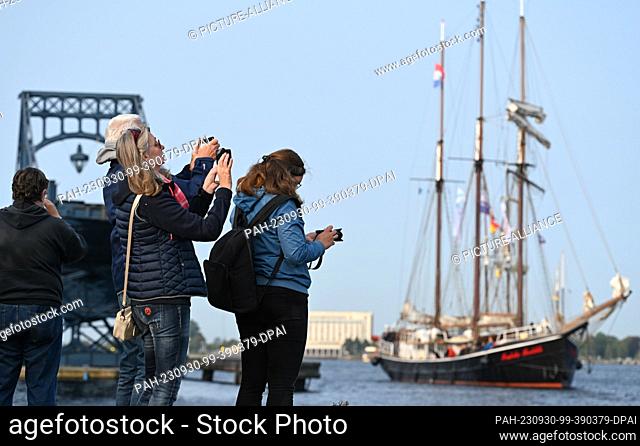 30 September 2023, Lower Saxony, Wilhelmshaven: Spectators watch the sailing ships set sail for a regatta as part of the 21st Wilhelmshaven Sailing-CUP