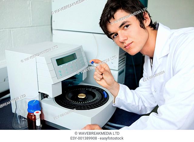 Student posing with a centrifuge in a laboratory