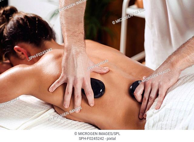 Young woman having hot stone massage