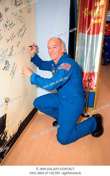 In the Korolev Museum at the Baikonur Cosmodrome in Kazakhstan, Expedition 47-48 crewmember Jeff Williams of NASA signs a wall mural March 14 as part of final...