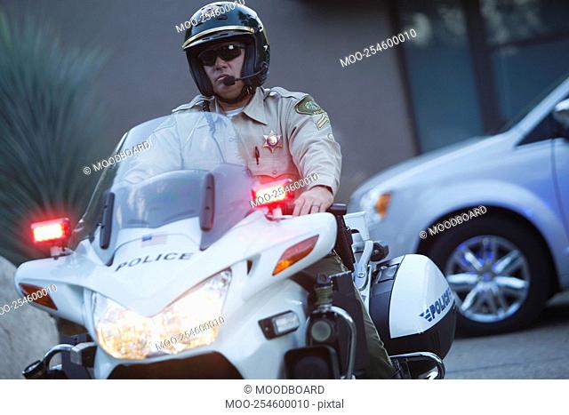 Patrol officer sits on motorcycle with hazrd lights lit