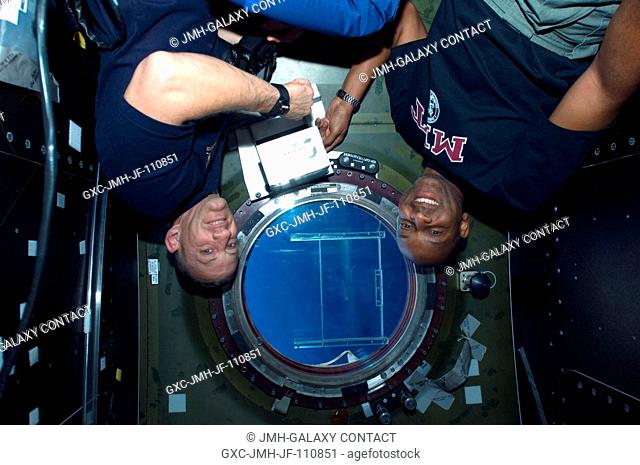 Astronauts Charles O. Hobaugh (left), STS-129 commander; and Robert L. Satcher Jr., mission specialist, are pictured near a window in the Destiny laboratory of...