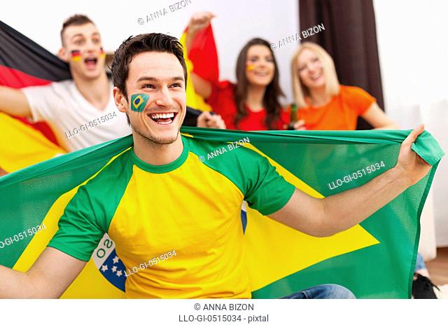 Brazilian man with friends from different country enjoying the soccer on TV. Debica, Poland