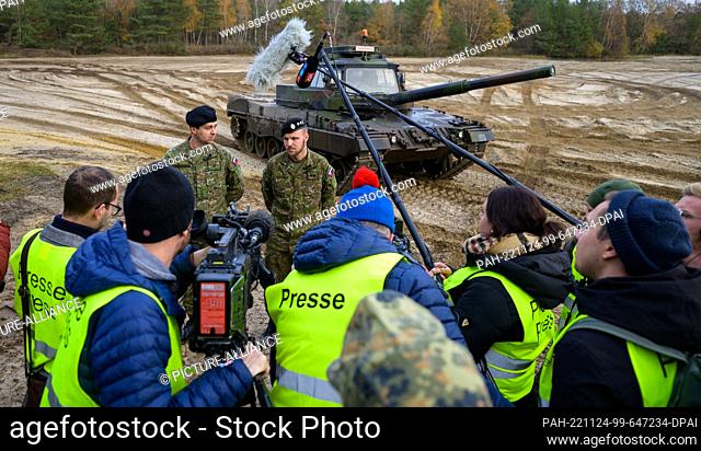 24 November 2022, Lower Saxony, Munster: Slovakian soldiers give an interview to media representatives in front of a Bundeswehr Leopard II driving school tank