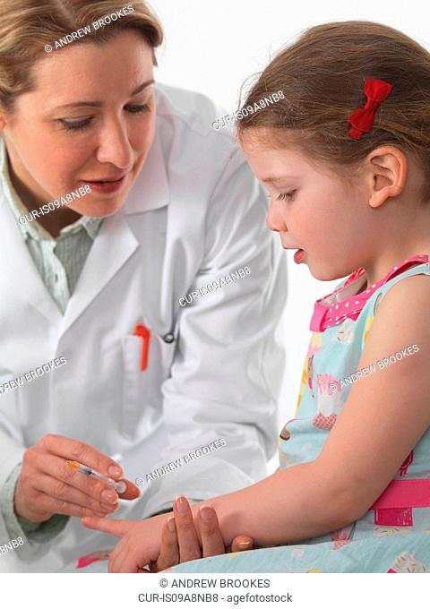 General practice doctor vaccinating a small girl in surgery