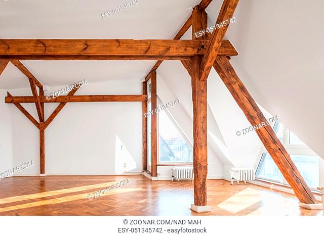 empty loft room with wooden framework and parquet floor
