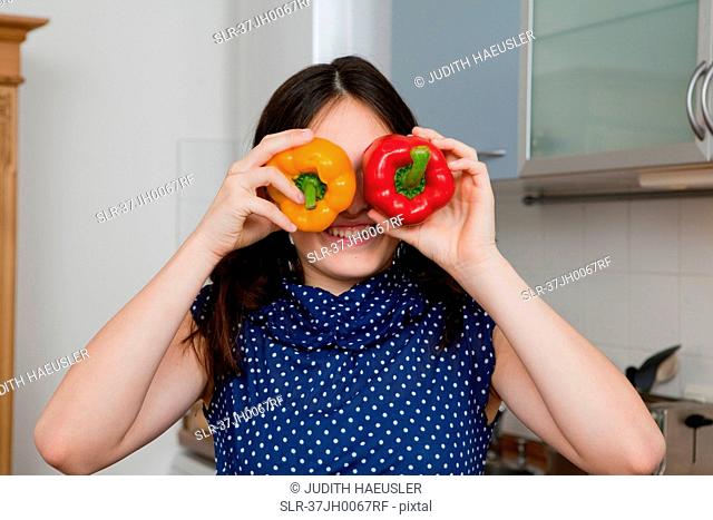 Smiling girl playing with bell peppers