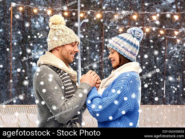 happy couple in winter clothes holding hands