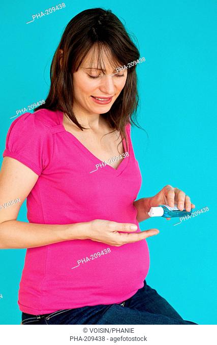 Pregnent woman washing her hands with hydroalcoholic gel, as recommended by the Minister of Health in case of viral respiratory diseases, common cold, influenza