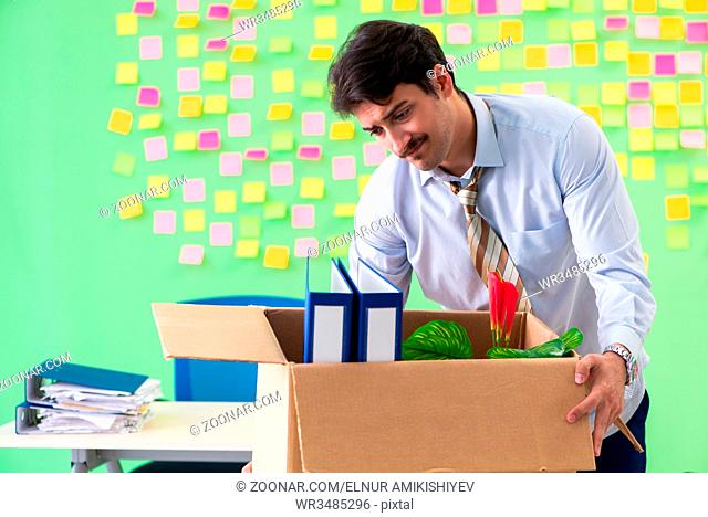 Man collecting his stuff after redundancy in the office with many conflicting priorities
