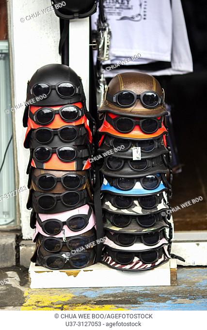Sunglasses on vintage helmets for display and sale at Seminyak Street, Bali