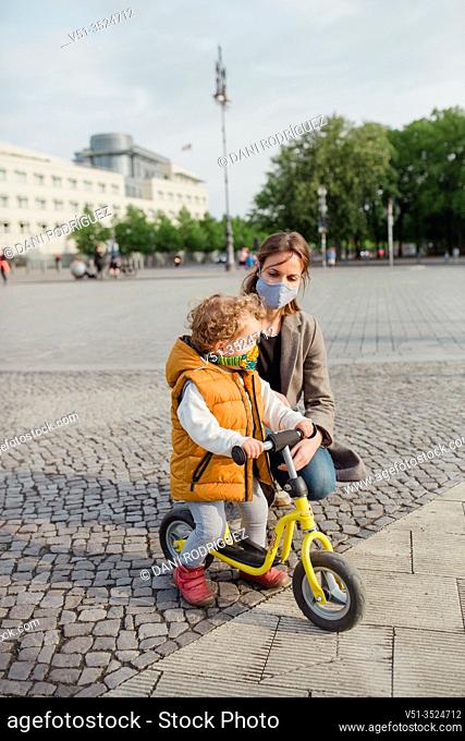 Little boy 2-3 years old with mask and bicycle in Berlin
