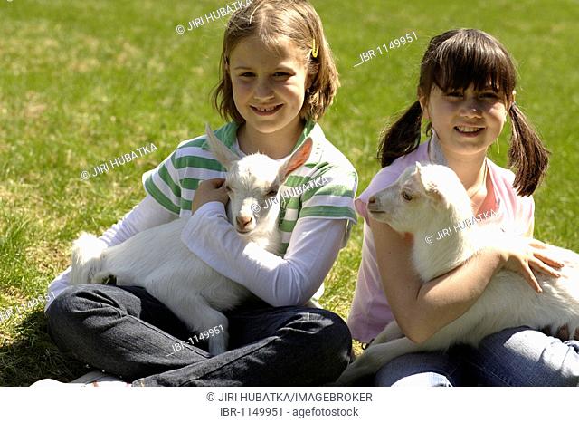 Two 8-year-old girls with a goatling